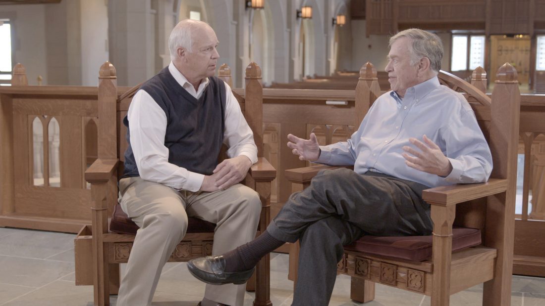 Doug Kelly and Del Tackett talking in a church