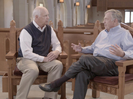 Doug Kelly and Del Tackett talking in a church